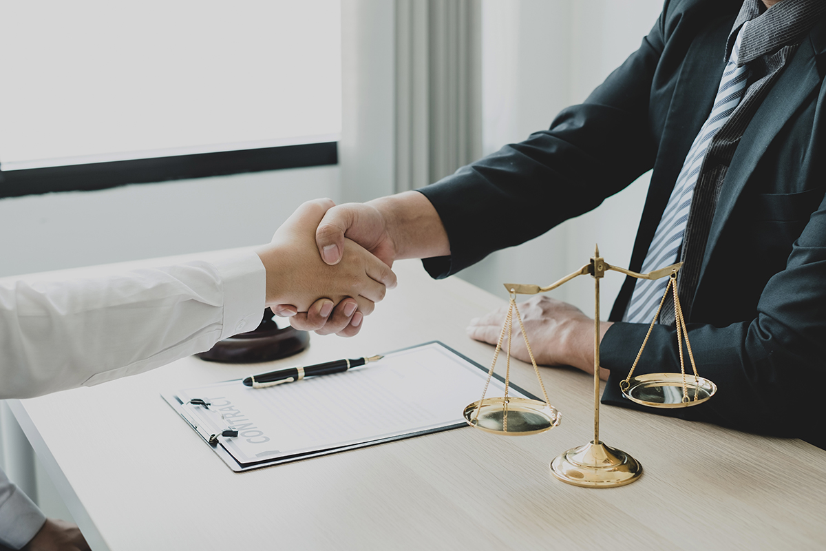 shake hand Professional man lawyers work at a law office There are scales, Scales of justice, judges gavel, and litigation documents. Concepts of law and justice.